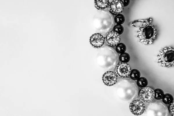 Beaux bijoux précieux brillants précieux bijoux glamour à la mode, collier et boucles d'oreilles avec perles et diamants, diamants sur un fond noir et blanc. Pose plate, vue du dessus, endroit de copie — Photo