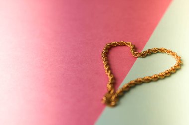 Doku güzel altın şenlikli zinciri pembe mor mavi arka plan ve bir kopya alanı üzerinde bir kalp şeklinde dokuma benzersiz