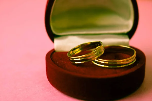 En vacker röd festlig present box sammet två förlovningsringar, vigselringar med dyrbara guld runt dyrbara högen ringar. Koncept: frieri, bröllop, engagemang — Stockfoto