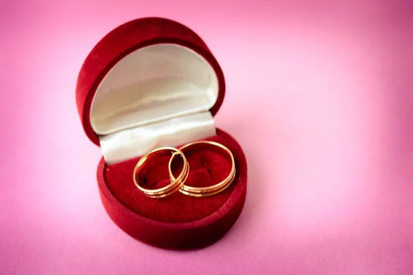 En vacker röd festlig present box sammet två förlovningsringar, vigselringar med dyrbara guld runt dyrbara högen ringar. Koncept: frieri, bröllop, engagemang — Stockfoto