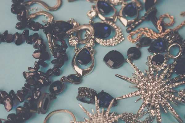 Krásné lesklé šperky módní okouzlující šperky set, náhrdelník, náušnice, prsteny, řetízky, brože s perlami a diamanty na modrém pozadí. Plochá ležel, horní pohled, kopie místo — Stock fotografie