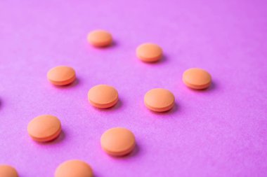 Küçük sarı turuncu güzel tıbbi pharmaceptic yuvarlak hapları, vitamin, uyuşturucu, bir mor pembe, doku antibiyotik. Konsept: tıp, sağlık. Düz yatıyordu, en iyi görünümü