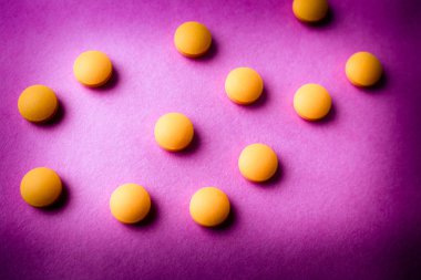 Küçük sarı turuncu güzel tıbbi pharmaceptic yuvarlak hapları, vitamin, uyuşturucu, bir mor pembe, doku antibiyotik. Konsept: tıp, sağlık. Düz yatıyordu, en iyi görünümü