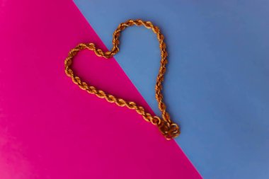 Doku güzel altın şenlikli zinciri pembe mor mavi arka plan ve bir kopya alanı üzerinde bir kalp şeklinde dokuma benzersiz