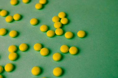 Küçük sarı turuncu güzel tıbbi pharmaceptic yuvarlak hapları, vitamin, uyuşturucu, mavi bir arka plan doku antibiyotik. Konsept: tıp, sağlık. Düz yatıyordu, en iyi görünümü