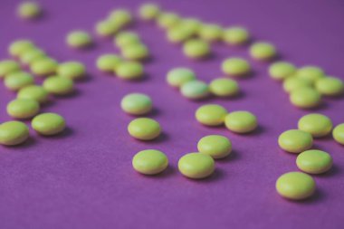 Küçük sarı turuncu güzel tıbbi pharmaceptic yuvarlak hapları, vitamin, uyuşturucu, bir mor pembe, doku antibiyotik. Konsept: tıp, sağlık. Düz yatıyordu, en iyi görünümü