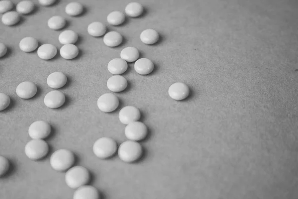 Little beautiful medical pharmaceptic round pills, vitamins, drugs, antibiotics on a black and white background, texture. Concept: medicine, health care. Flat lay, top view — Stock Photo, Image