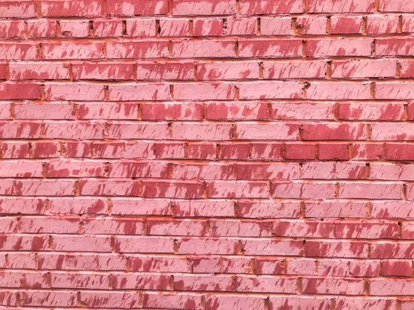 Textur einer schönen einzigartigen ungewöhnlichen rosa zarten alten rissigen Ziegelwand aus rechteckigen Ziegeln mit Nähten mit rosa alter schäbiger Farbe bemalt. der Hintergrund — Stockfoto