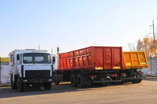 Grands camions lourds avec cabines et remorques, camions à benne se tiennent dans une rangée dans le stationnement prêt pour la livraison — Photo