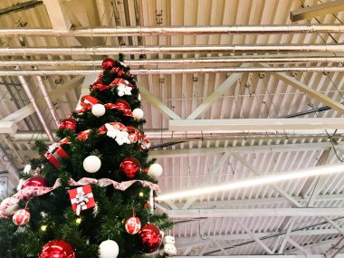 Festival yeşil güzel zarif ile Noel ağacı topları tavan loft tarzında metal havalandırma boruları ile arka plan üzerinde yeni yıl için. Konsept: Noel endüstriyel bir tesisi