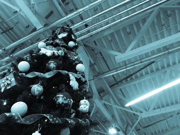 Εορταστική πράσινο όμορφο κομψό χριστουγεννιάτικο δέντρο με μπάλες για το νέο έτος για το φόντο της οροφής με σωλήνες μετάλλων εξαερισμού σε στιλ σοφίτας. Έννοια: Χριστούγεννα στο ενός βιομηχανικού συγκροτήματος — Φωτογραφία Αρχείου