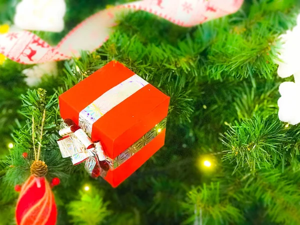Belas bolas extravagantes brilhantes multicoloridas festivas, brinquedos, caixas de presente, decorações na árvore verde de Natal com agulhas e ramos para o Ano Novo com um efeito de borrão. Contexto, textura — Fotografia de Stock