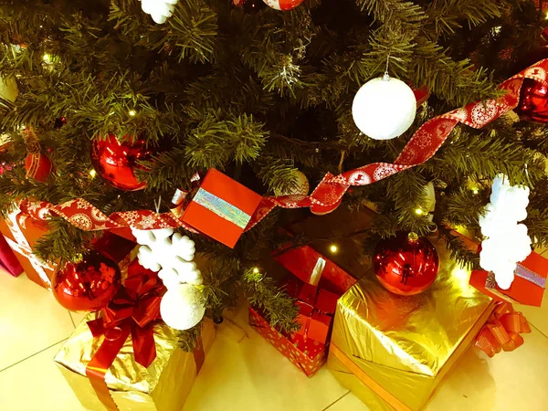 节日五颜六色的美丽闪亮的礼品盒, 装饰下的圣诞树下的针和树枝, 玩具为新年。背景、纹理 — 图库照片