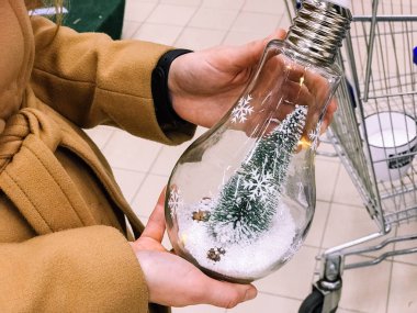 Festival güzel yeşil ile Noel ağacı iğneler ve dalları, cam ampul, bir kızın elinde yeni yıl için bir oyuncak. Konsept: Noel hediye fikir