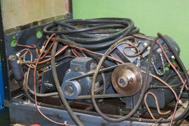 Tüpler ve hortumlar ile eski Asenkron elektrik motoru, bir sanayi fabrikasında tahrik kemer