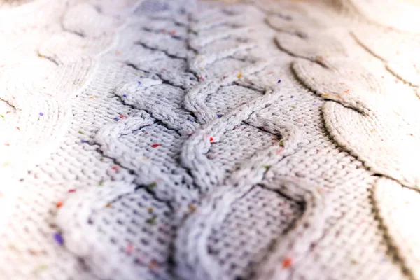 Bela textura de um suéter natural quente macio com um padrão tricotado de fios. O fundo — Fotografia de Stock