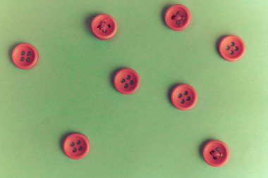 Güzel doku dikiş, dikiş için birçok yuvarlak kırmızı düğmeli. Uzay kopyalayın. Düz yatıyordu. Yeşil arka plan