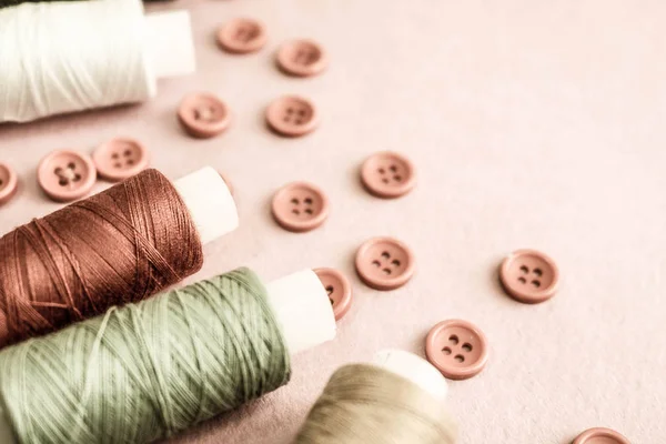 Schöne Textur mit vielen runden roten Knöpfen zum Nähen, Handarbeiten und Knäueln von Fadenspulen. Kopierraum. flach lag. rosa, lila Hintergrund — Stockfoto