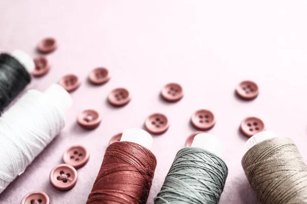 Schöne Textur mit vielen runden roten Knöpfen zum Nähen, Handarbeiten und Knäueln von Fadenspulen. Kopierraum. flach lag. rosa, lila Hintergrund — Stockfoto