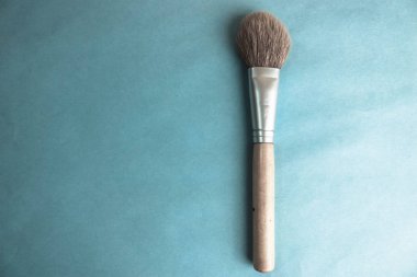 Güzel yumuşak fırça güzellik ve uygulanan ton çerçeve ahşap kalem ve bir kopya alanı üzerinde mavi bir arka plan ile rehberlik için doğal hav makyaj için