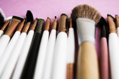 Güzel farklı yumuşak fırçalar makyaj için doğal hedefleme ve stand ve kopya bir alanı bir ton temel bir pembe, mor arka plan üzerinde uygulama güzellik uykusuna üzerinden bir dizi