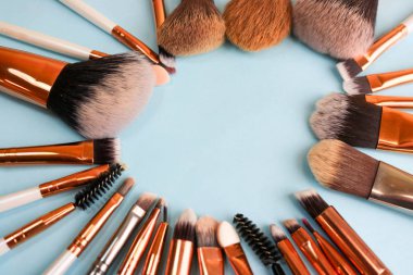 Bir çerçeve güzel farklı yumuşak makyaj fırça güzellik hedefleme ve stand ve kopya bir alanı ton bir temel üzerinde mavi bir arka plan uygulamak için doğal tüysüz üzerinden bir dizi