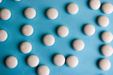 Güzel doku ile beyaz yuvarlak düzgün tıbbi ilaçlar, vitaminler, antibiyotikler ve mavi bir arka plan üzerinde yer kopyalayın. Düz yatıyordu