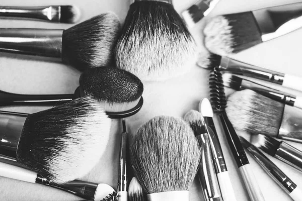 A set of beautiful black and white different soft brushes for make-up from natural nap for beauty guidance and applying a tonal base in the stand