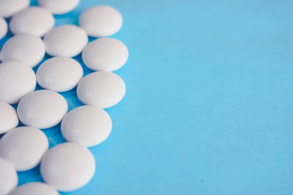Красивая текстура с белым круглой гладкой медицинской таблетки, витамины, антибиотики и копировать пространство на синем фоне. Плоский лежал — стоковое фото