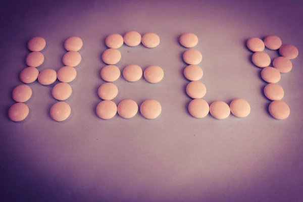 Hermosa ayuda inscripción hecha de píldoras médicas lisas redondas blancas, vitaminas, antibióticos y espacio de copia sobre un fondo rosa púrpura brillante. Puesta plana —  Fotos de Stock