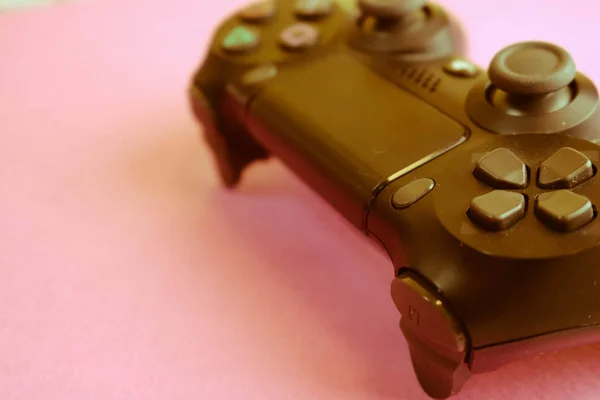 Un bellissimo joystick digitale nero moderno per controllare una console di videogiochi per videogiochi con pulsanti e tasti e copiare spazio su uno sfondo viola rosa — Foto Stock