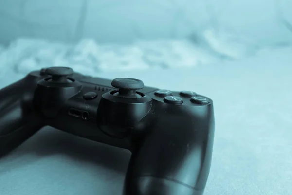 A beautiful black modern digital gaming joystick to control a video game console for video games with buttons and keystrokes and copy space on a blue background — Stock Photo, Image