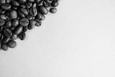 Güzel dokusu seçili lezzetli zengin kahverengi doğal hoş kokulu kahve ağacı tahıl, Arabica kahve çekirdekleri, Robusta taze kavrulmuş. Yat ve siyah ve beyaz bir arka plan üzerinde yer kopyalayın