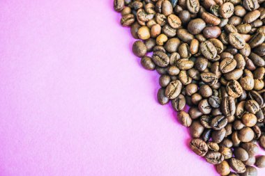 Güzel dokusu seçili lezzetli zengin kahverengi doğal hoş kokulu kahve ağacı tahıl, Arabica kahve çekirdekleri, Robusta taze kavrulmuş. Yat ve yer üstünde mor pembe kopyalamak