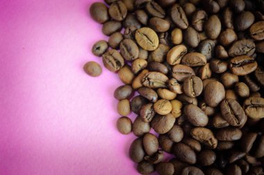 Güzel dokusu seçili lezzetli zengin kahverengi doğal hoş kokulu kahve ağacı tahıl, Arabica kahve çekirdekleri, Robusta taze kavrulmuş. Yat ve yer üstünde mor pembe kopyalamak
