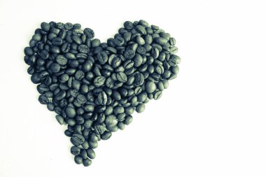 Güzel doku taze kavrulmuş seçili lezzetli doymuş kahverengi doğal güzel kokulu Arabica ve Robusta kahve fasulye bir kalp şeklinde. Kopya alanı, düz yatıyordu, izole beyaz arka plan