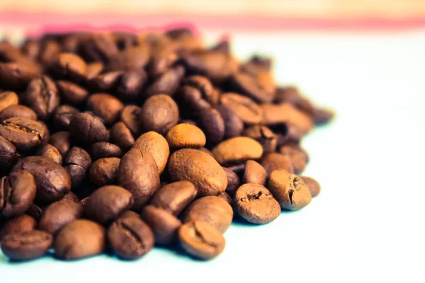 Beautiful texture of freshly roasted selected delicious rich brown natural fragrant coffee tree grains, Arabica coffee beans, Robusta. Copy space on blue background — Stock Photo, Image