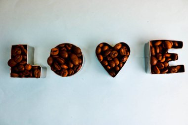 Güzel doku kavrulmuş seçili kahverengi doğal aromatik Arabica kahve çekirdekleri yapılan Sevgililer günü yazıt için word sevgiyle robusta kopya alanı, düz yatıyordu, mavi arka plan