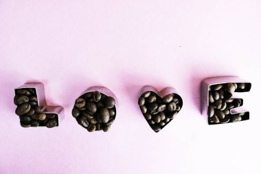 Güzel doku kavrulmuş seçili kahverengi doğal aromatik Arabica kahve çekirdekleri yapılan Sevgililer günü yazıt için word sevgiyle robusta kopya alanı, düz yatıyordu, mor pembe