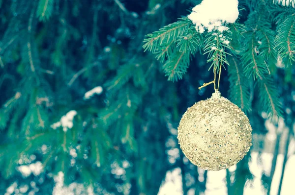 Piękny uroczysty elegancki żółty, złoty okrągłe kulki, ozdoby świąteczne na nowy rok, Boże Narodzenie, wiszące na gałęzie jodły na tle białego śniegu w zimie — Zdjęcie stockowe
