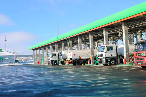Grande station-service industrielle verte pour le ravitaillement des véhicules, camions et réservoirs avec carburant, essence et diesel en hiver — Photo