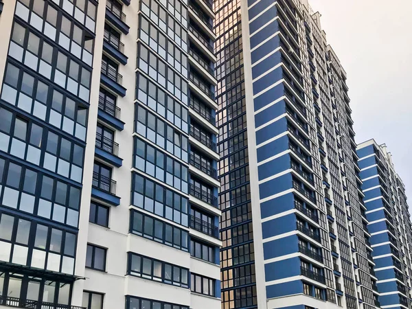 Edifício de armação monolítico moderno alto azul, casa, novo edifício, um arranha-céu com janelas espelhadas contra um céu azul. Conceito: realocação, alojamento do painel, problema de habitação, arquitetura moderna — Fotografia de Stock