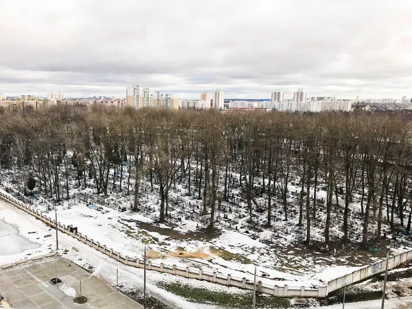 Eski şehir mezarlık ağaçlarıyla bir yükseklikten parkta ve evleri kışın penceresinden görünümü. Şehir Panoraması — Stok fotoğraf