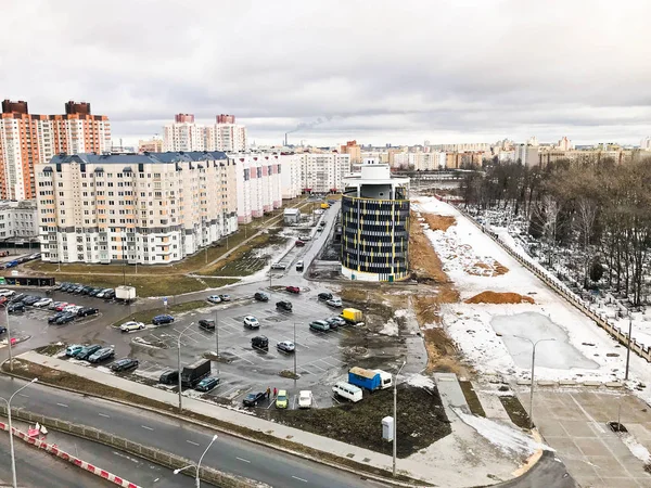 Вид из окна с высоты городской автострады на строительство домов и парковку в зимний период. Панорама города — стоковое фото