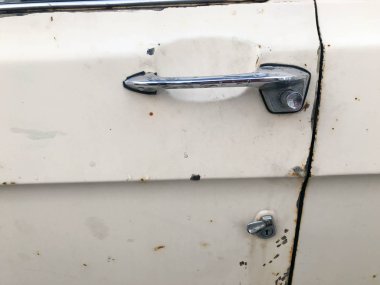 60'lar, 70'lerin, 80s, 90'lı yılların, 2000'lerde bir antiquan beyaz Amerikan binek otomobil için retro bir düğme ile eski bir retro vintage hipster paslı oksitlenmiş krom metal gümüş kapı kolu