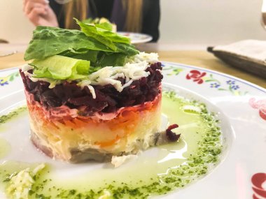 Bir kafe veya restoranda masada bir plaka üzerinde pancar ve balık lezzetli lezzetli mor Rus salatası 