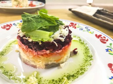 Bir kafe veya restoranda masada bir plaka üzerinde pancar ve balık lezzetli lezzetli mor Rus salatası 