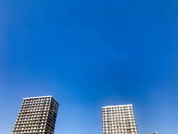 Dua besar beton bertulang tinggi, panel, monolitik-frame, frame-blok rumah, bangunan, pencakar langit, gedung-gedung baru dengan silau matahari di jendela terhadap langit biru — Stok Foto