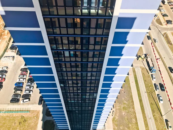 从一座高楼屋顶的高度来看, 院子里有一座摩天大楼的楼顶, 院子里的汽车就在新大楼的另一栋蓝色框架街区大楼对面 — 图库照片