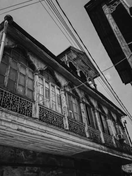 Czarno-biały stary antyczny balkon drewnianego domu Europejskiego. Europejskiej starej architektury. Zdjęcie pionowe — Zdjęcie stockowe